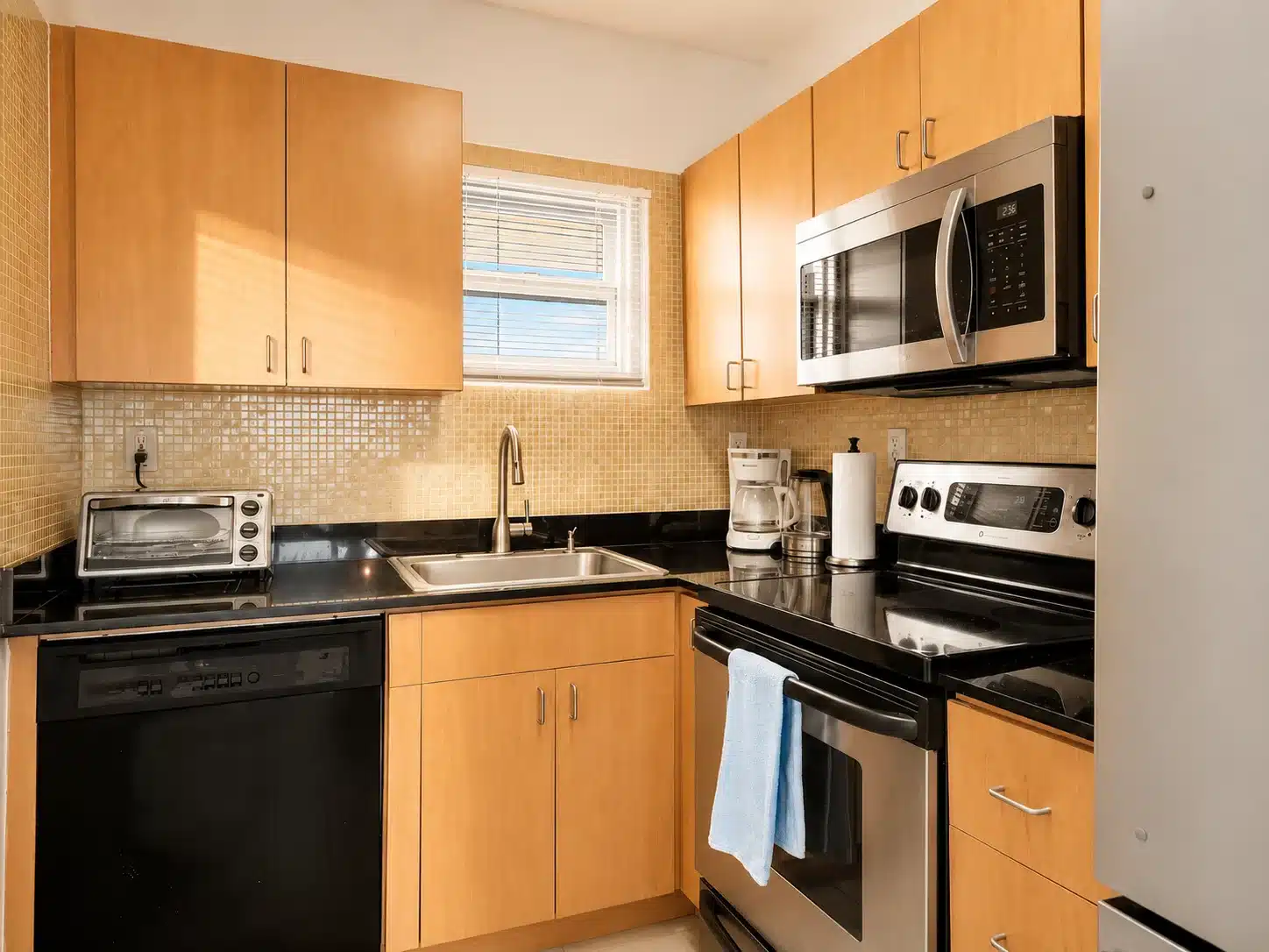 Kitchen at a South of Fifth Art Basel Miami Beach rental with wood cabinetry and full appliances