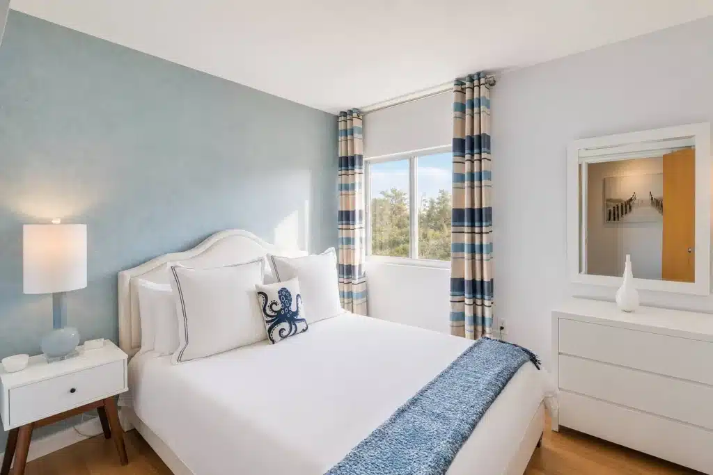 Modern nautical bedroom with white upholstered bed and blue accents where to stay Miami Dade