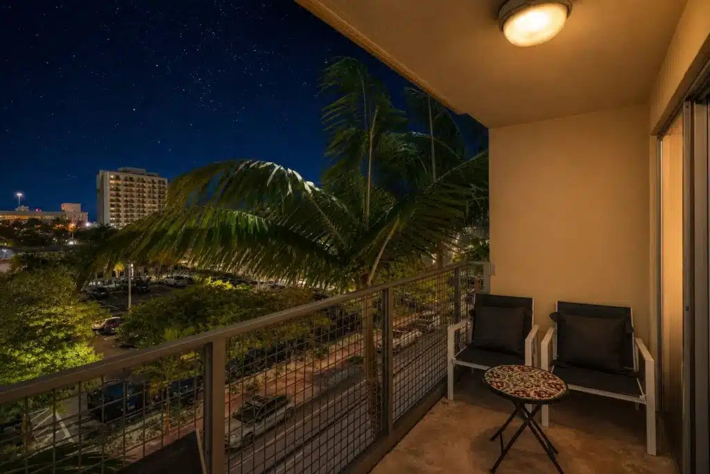 Luxury balcony with seating overlooking palm trees at Miami Beach vacation home rental