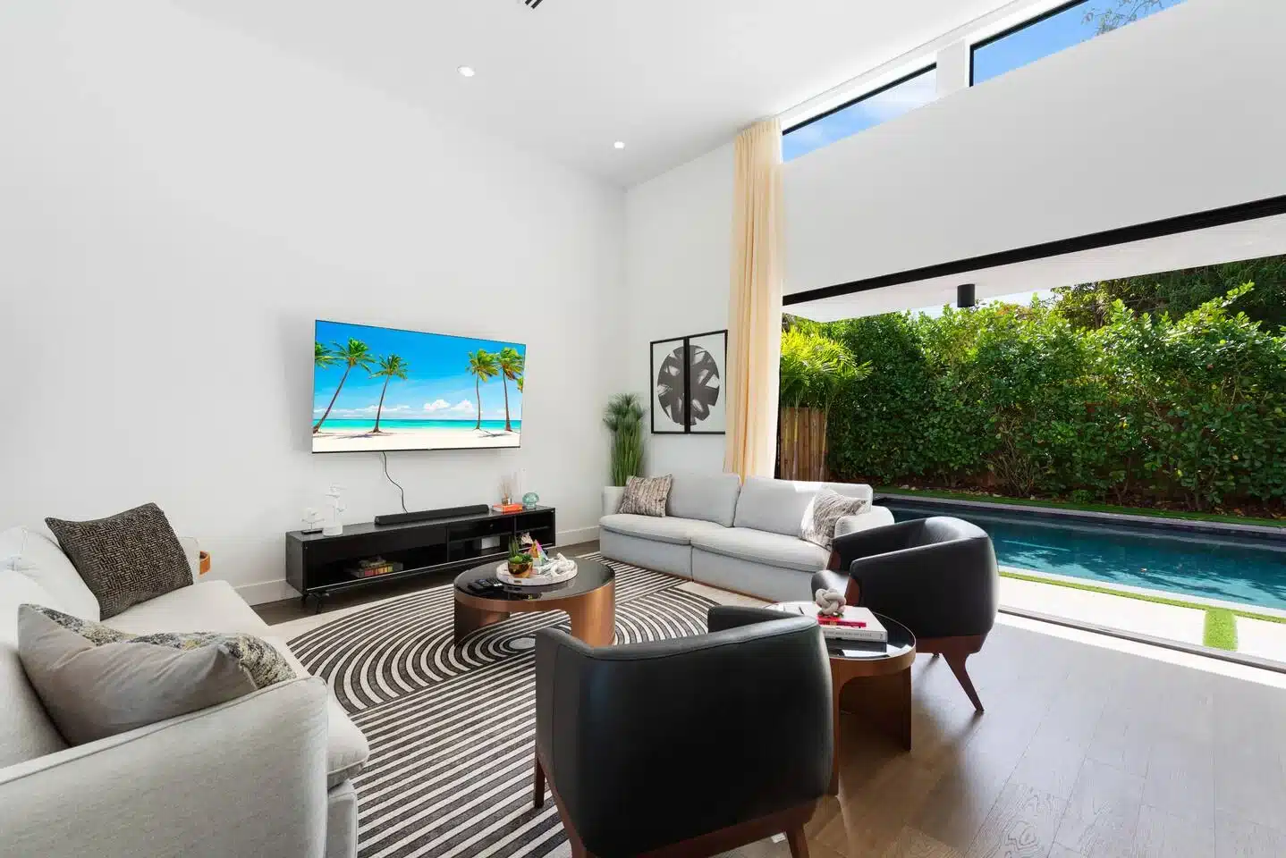 Modern living room with private pool view and contemporary furnishings in Miami Beach luxury rental