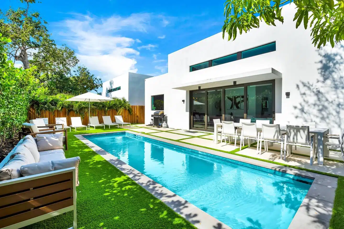 Turquoise heated pool and modern villa exterior, a vacation home rental Florida option in Miami's Design District