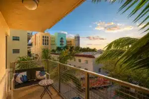 Waterfront balcony view of colorful Art Deco buildings, palm trees, and river boats, ideal for a bachelorette getaway in