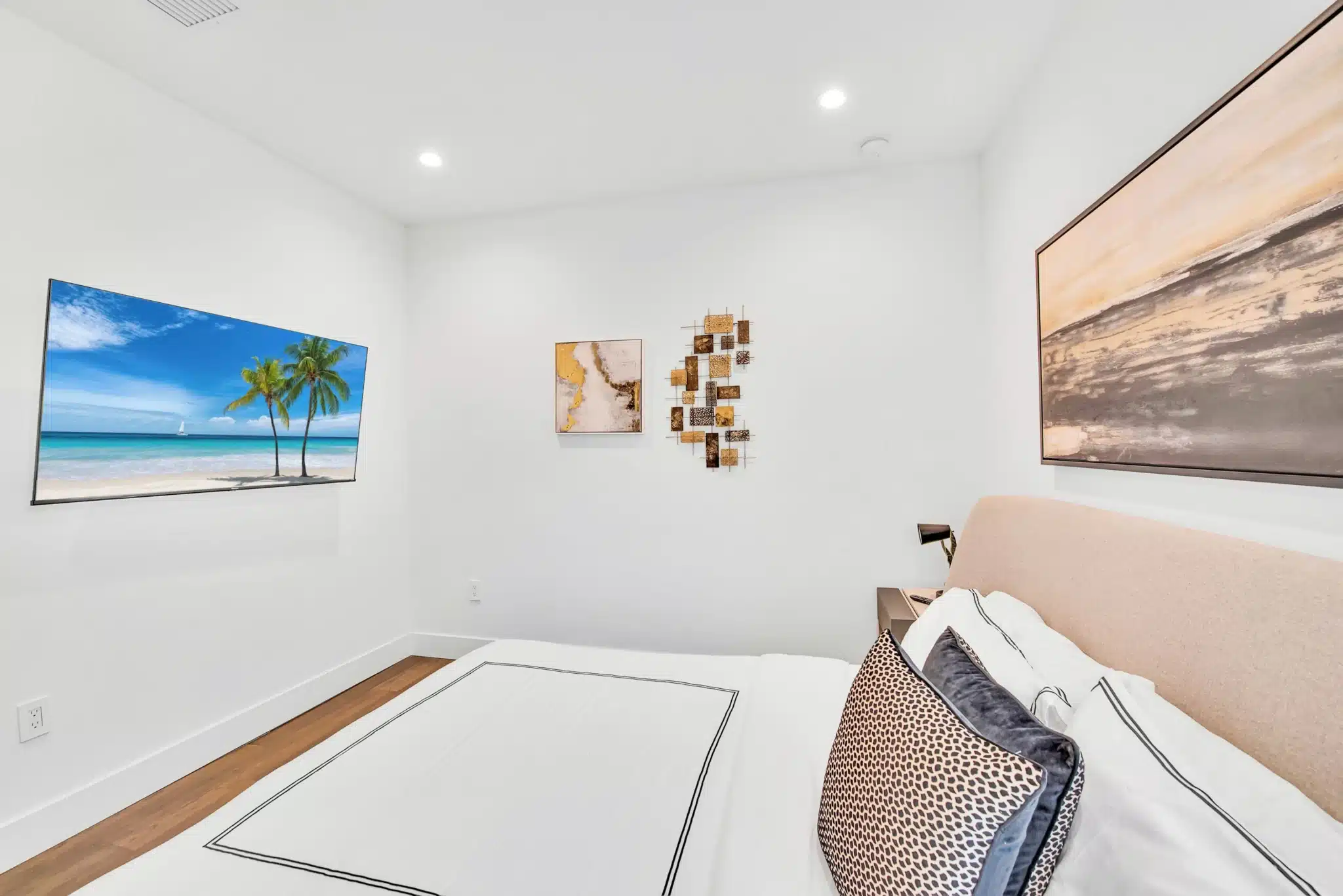 Modern bedroom with beach art and gold decor in Miami vacation rental