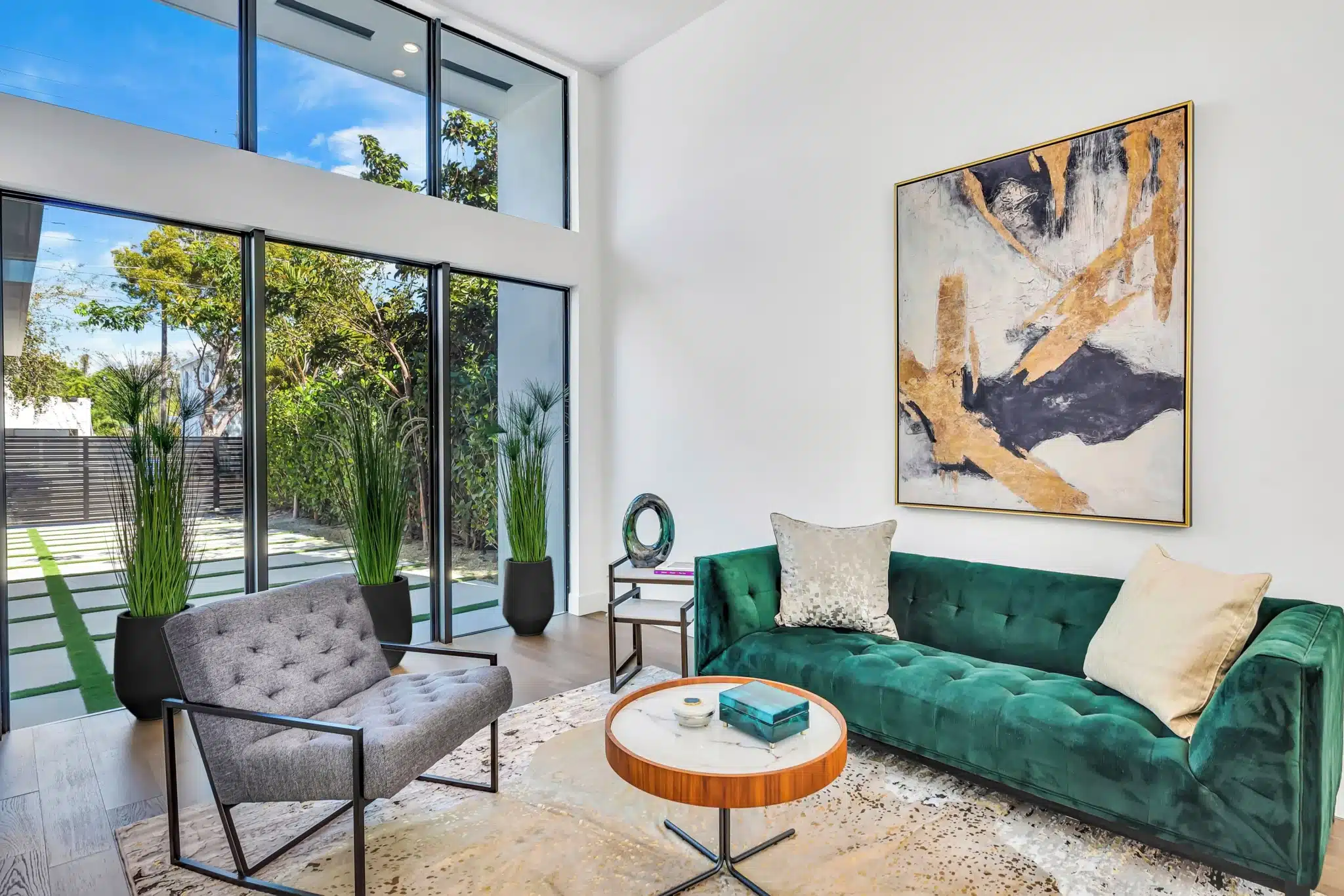 Modern living room with floor-to-ceiling windows and emerald sofa, ideal for Miami vacation rental groups